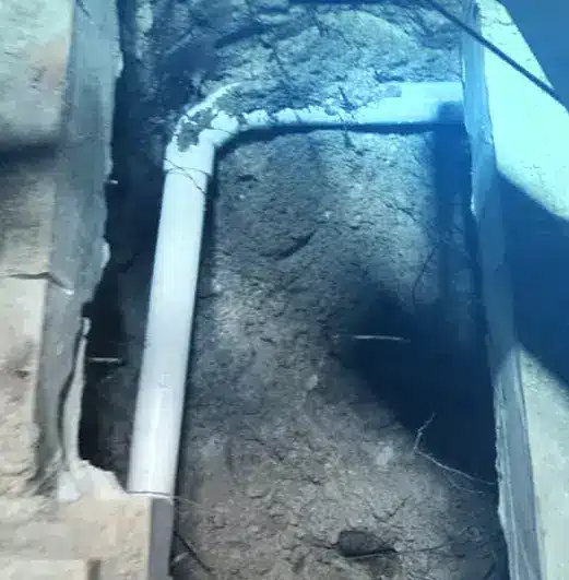 A pool leak detection company discovered a pipe in the ground next to a wall.